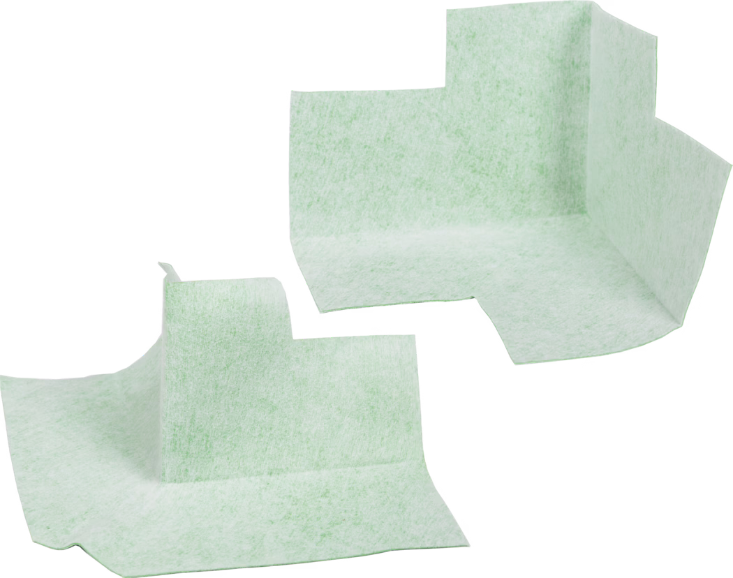 codex Dichtecke Innen/Aussen Two light mint-green disposable absorbent corner liners photographed against a white background. The non-woven, textured pads are preformed with a raised vertical corner and flat surrounding flanges, suggesting use as shaped underpads or protective liners for furniture, medical or hygiene applications. The material appears soft, fibrous and slightly translucent with a mottled texture; edges are irregularly cut. The liners are shown separated and oriented at different angles, highlighting the three-dimensional folded shape and the flat base areas designed to collect liquids or protect surfaces.